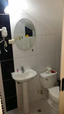 a bathroom with a sink and a toilet and a mirror at Apartamento Frente Al Mar in San Felipe de Puerto Plata