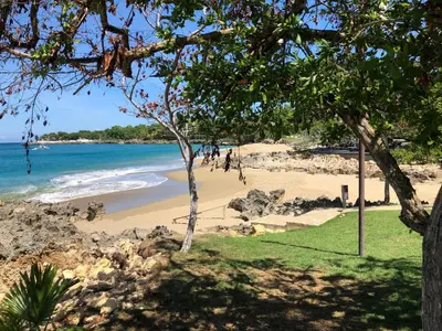 a beach with people walking on the sand at Comfortable Apartment in Caribbean Paradise in Sosúa