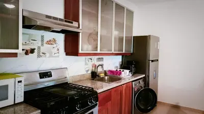 a small kitchen with a stove and a sink at Comfortable Apartment in Caribbean Paradise in Sosúa