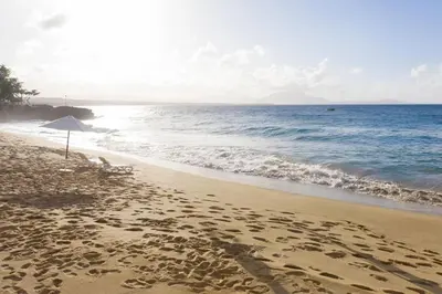 a sandy beach with an umbrella and the ocean at Casa Marina Sosua, Trademark by Wyndham All Inclusive in Sosúa
