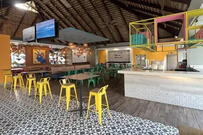 a restaurant with a bar with yellow and green stools at Casa Marina Sosua, Trademark by Wyndham All Inclusive in Sosúa