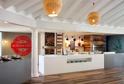 a restaurant with a white counter with aasteryasteryasteryasteryasteryasteryasteryastery at VH - Gran Ventana Beach Resort in San Felipe de Puerto Plata