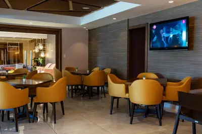 a restaurant with tables and chairs and a tv on the wall at Hotel Aladino in Santo Domingo
