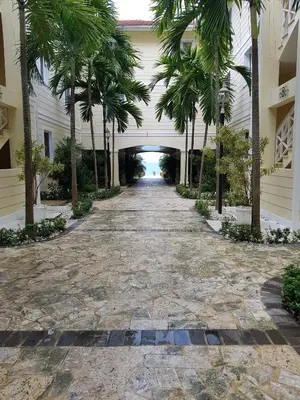 a hallway of a resort with palm trees and a tunnel at Luxury Oceanview Condo 2 BR/2.5 BA in Sosúa
