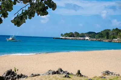 a boat in the water on a beach at Luxury Oceanview Condo 2 BR/2.5 BA in Sosúa