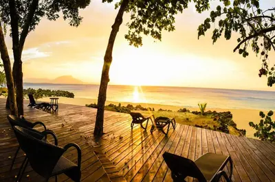 a wooden deck with chairs and a view of the ocean at Luxury Oceanview Condo 2 BR/2.5 BA in Sosúa