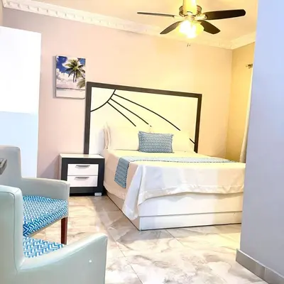 a bedroom with a bed and a ceiling fan at Hotel Sand Bay in Punta Rucia