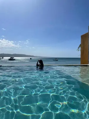 a woman swimming in a pool of water at Hotel Sand Bay in Punta Rucia