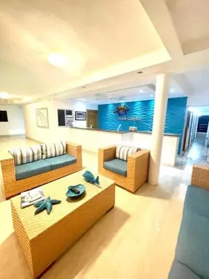 a living room with two couches and a table at Hotel Sand Bay in Punta Rucia