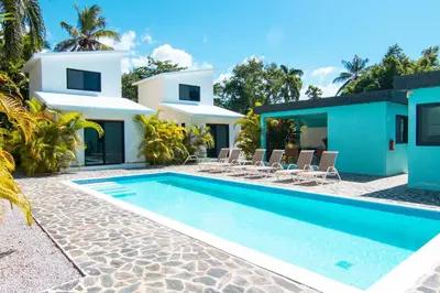 a villa with a swimming pool in front of a house at Residence Las Dos Palmas in Las Terrenas