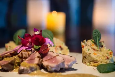 a plate with a piece of cake with a flower on it at Natura Cabana Boutique Hotel & SPA by Mint in Cabarete