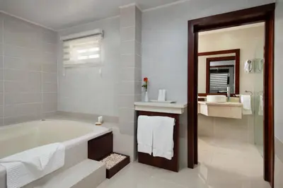 a white bathroom with a tub and a sink at Hodelpa Centro Plaza in Santiago de los Caballeros