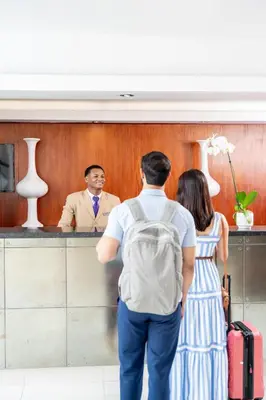 a man and a woman standing at a counter at Hodelpa Centro Plaza in Santiago de los Caballeros