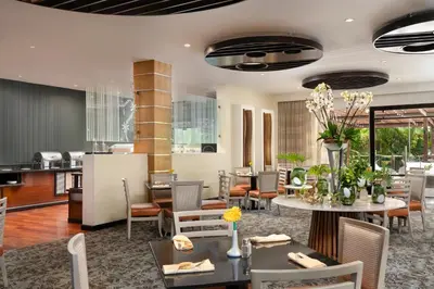 a dining room with tables and chairs at Hodelpa Garden Court in Santiago de los Caballeros