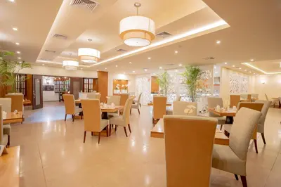 a dining room with tables and chairs in a restaurant at Hodelpa Gran Almirante in Santiago de los Caballeros