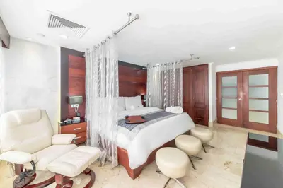 a bedroom with a bed and a desk and chairs at Hodelpa Gran Almirante in Santiago de los Caballeros