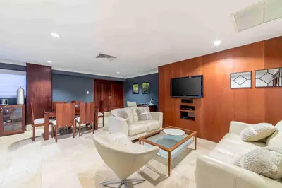 a living room with white furniture and a tv at Hodelpa Gran Almirante in Santiago de los Caballeros