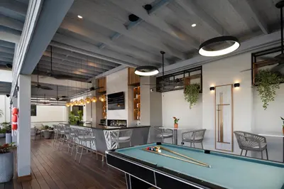 a pool table in a room with a bar at Hodelpa Gran Almirante in Santiago de los Caballeros