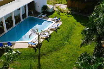 an overhead view of a swimming pool with chaise lounge chairs at Hotel Marimba Punta Cana in Punta Cana