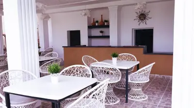 a row of white tables and chairs in a room at Hotel Marimba Punta Cana in Punta Cana