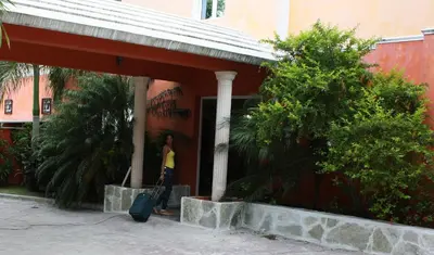 a woman walking into a building with her luggage at Hotel Marimba Punta Cana in Punta Cana