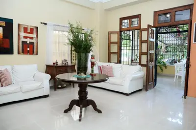 a living room with a table with a vase of flowers on it at Hostal Bella Epoca in Santo Domingo