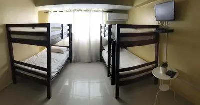 two bunk beds in a room with a television at Hostal Bella Epoca in Santo Domingo