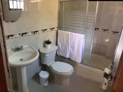 a bathroom with a toilet and a sink and a shower at Hostal Bella Epoca in Santo Domingo