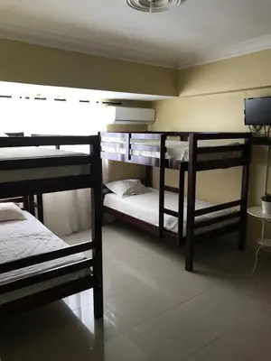 a room with three bunk beds and a television at Hostal Bella Epoca in Santo Domingo