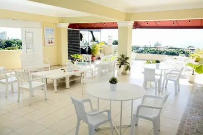 a restaurant with white tables and white chairs at Hostal Bella Epoca in Santo Domingo