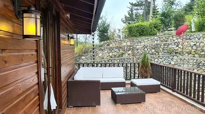 a porch with a bench and a table and a stone wall at Villa The sky village in Jarabacoa