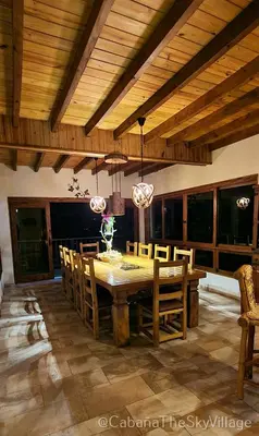a dining room with a wooden table and chairs at Villa The sky village in Jarabacoa