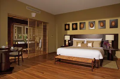 a bedroom with a bed and a table and a desk at Zoetry Agua Punta Cana - All Inclusive in Punta Cana