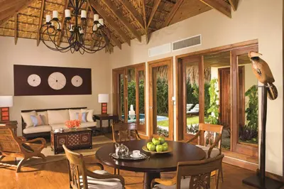 a living room with a table and chairs and a couch at Zoetry Agua Punta Cana - All Inclusive in Punta Cana