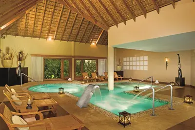a pool with a slide in a hotel room at Zoetry Agua Punta Cana - All Inclusive in Punta Cana