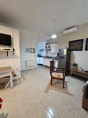 a living room with a chair and a kitchen at Apartamento Costa Azul en El Pueblito in San Felipe de Puerto Plata