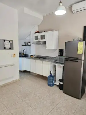 a kitchen with white cabinets and a stainless steel refrigerator at Apartamento Costa Azul en El Pueblito in San Felipe de Puerto Plata