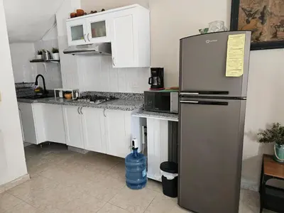 a kitchen with a stainless steel refrigerator and white cabinets at Apartamento Costa Azul en El Pueblito in San Felipe de Puerto Plata