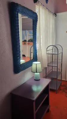a mirror on a wall next to a table with a lamp at Il Triangolo Hostel in Las Galeras