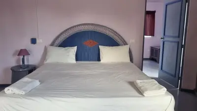 a bedroom with a large bed with a blue headboard at Il Triangolo Hostel in Las Galeras