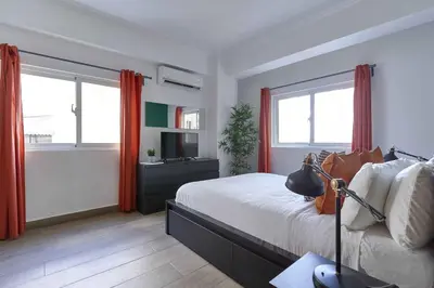 a bedroom with a bed with red curtains and a television at Central Park Tower in Santo Domingo