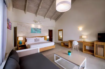 a hotel room with a bed and a living room at Vista Sol Punta Cana Beach Resort & Spa - All Inclusive in Punta Cana