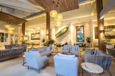 a lobby with blue chairs and tables in a building at Vista Sol Punta Cana Beach Resort & Spa - All Inclusive in Punta Cana