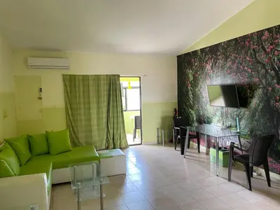 a living room with a green couch and a table at Apartment in Plaza Europa in Sosúa