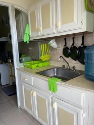 a kitchen with white cabinets and a sink at Apartment in Plaza Europa in Sosúa