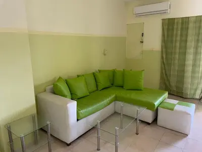 a living room with a green couch and two tables at Apartment in Plaza Europa in Sosúa