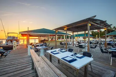 a restaurant with tables and chairs on a wooden deck at Hotel whala!boca chica - All Inclusive in Boca Chica
