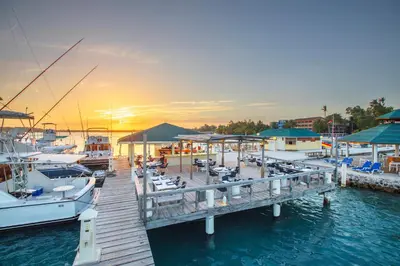 a dock with boats docked in the water at sunset at Hotel whala!boca chica - All Inclusive in Boca Chica