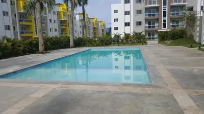 an empty swimming pool in front of some apartment buildings at Oasis Palma Real santiago, Republica Dominicana in Santiago de los Caballeros