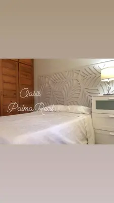 a bedroom with a white bed and a desk at Oasis Palma Real santiago, Republica Dominicana in Santiago de los Caballeros